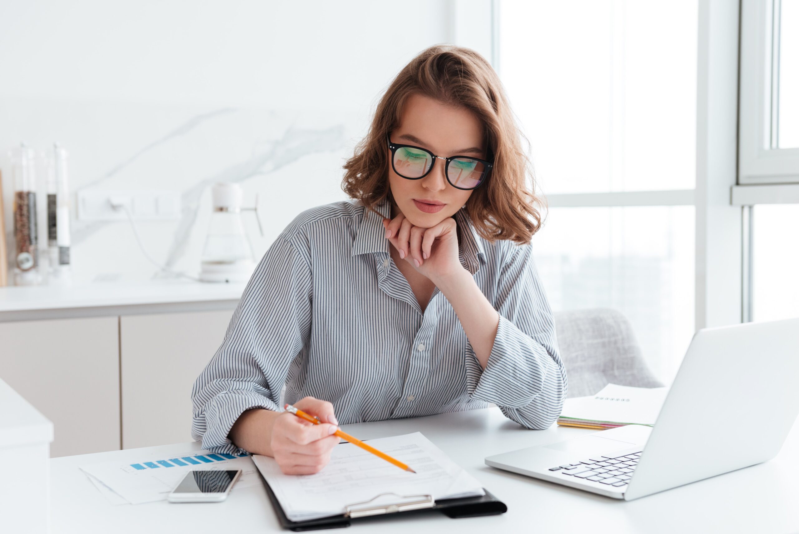 https://doradcy365.pl/wp-content/uploads/2021/10/young-concentrated-businesswoman-glasses-striped-shirt-working-with-papers-home-min-scaled.jpg
